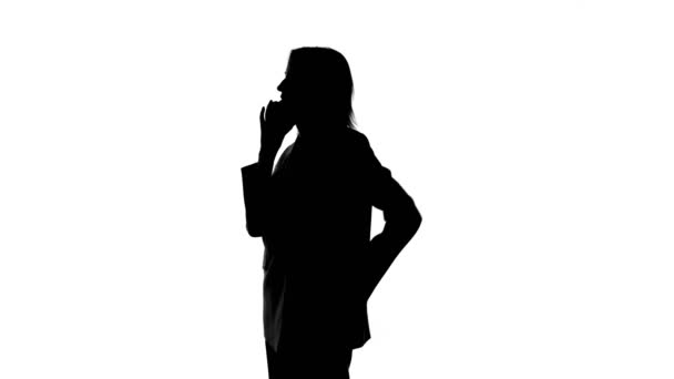 Záběry mluvení na telefon ženy silueta na izolovaném bílém pozadí — Stock video