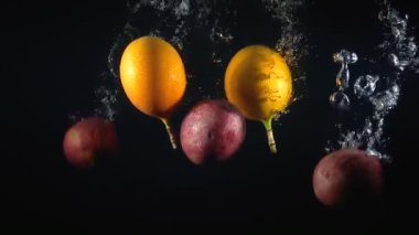 Siyah zemin üzerinde düşen marakuya grubu.