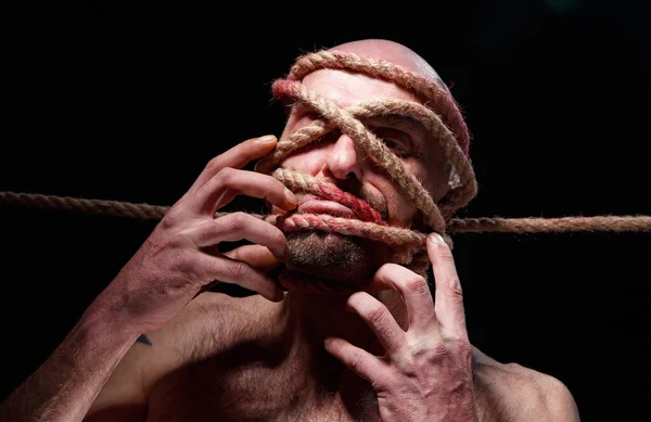 Image of binded bald man trying tear the rope on face — Stock Photo, Image