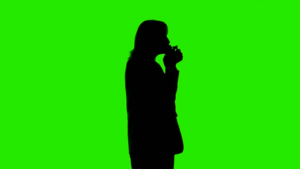 Video of smoking nervous womans silhouette on isolated green background — Stock Video