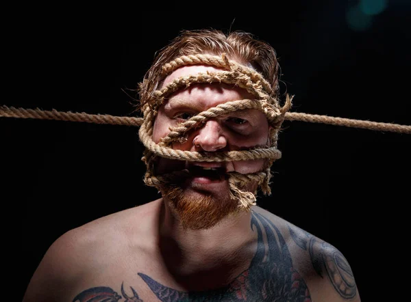 Foto di uomo tatuato legato con corda sul viso — Foto Stock