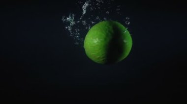 Siyah arkaplanda suya düşen avokado videosu