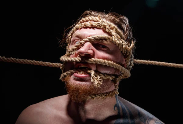 Retrato de homem tatuado amarrado com corda no rosto — Fotografia de Stock