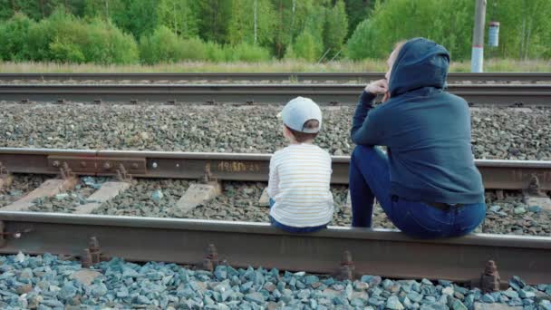 坐在铁轨上的妇女和男孩的形象 — 图库视频影像