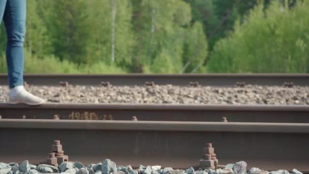 Yazın demiryolunda yürüyen bir kızın videosu. — Stok video