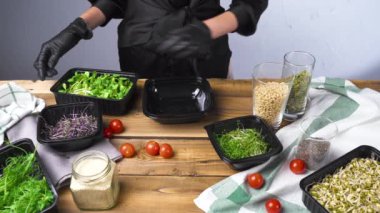 Siyah eldivenli bir kadın mikro yeşil salata pişiriyor.