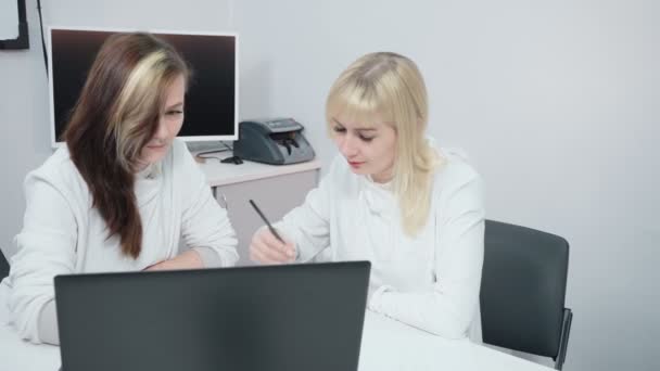 Schieten van twee zakenvrouwen die zaken op kantoor bespreken — Stockvideo