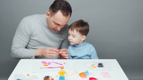 Video av far och son skulptera leksaker från plasticine — Stockvideo