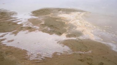 Kum kıyısında lastik botlarla yürüyen bir adamı vurmak.