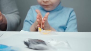 Baba ve küçük çocuğun plastikten hayvan yonttuğu görüntüler.