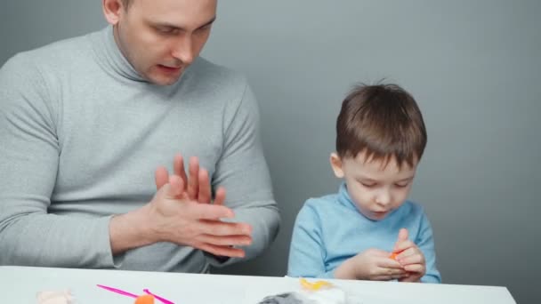 Video of dad and son sculpting animals from plasticine — Stock Video