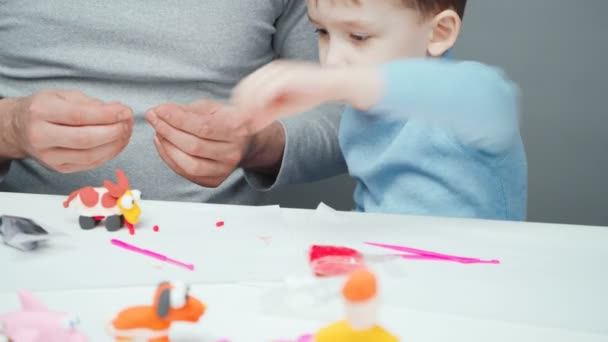 Baba ve küçük çocuk plastikten oyuncak yapıyorlar. — Stok video