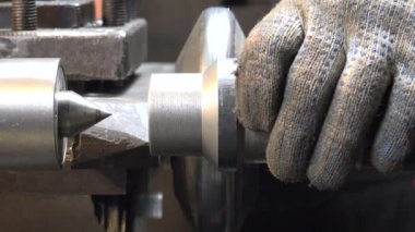 Torna tezgahında metalle çalışan bir adamın yakın çekim videosu.