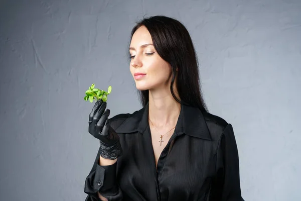 Foto de una mujer sosteniendo brotes verdes en la mano — Foto de Stock