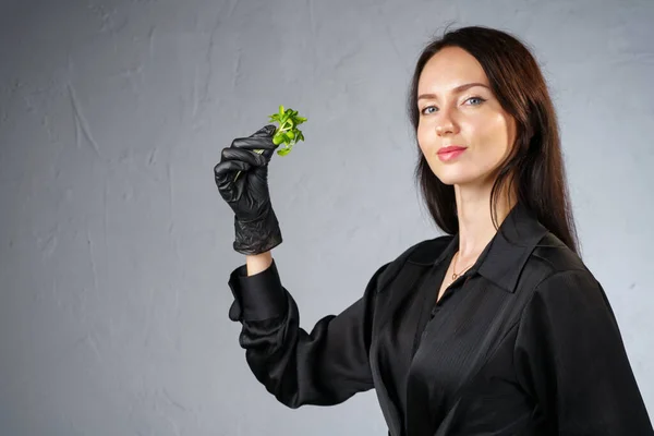 Foto de mujer morena sosteniendo brotes verdes en la mano — Foto de Stock