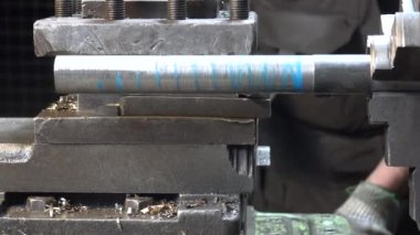 Torna tezgahında metal spiral yapan bir adamın videosu.