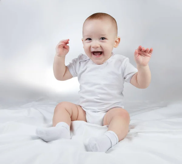 Foto de um bebê rindo de dez meses de idade com as mãos para cima em um fundo branco — Fotografia de Stock