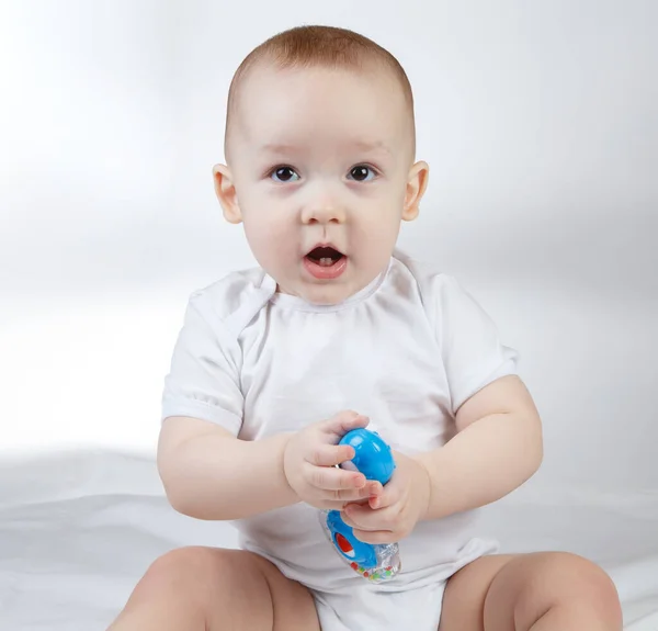 Image of a ten-month-old baby with blue rattle — Stock Photo, Image
