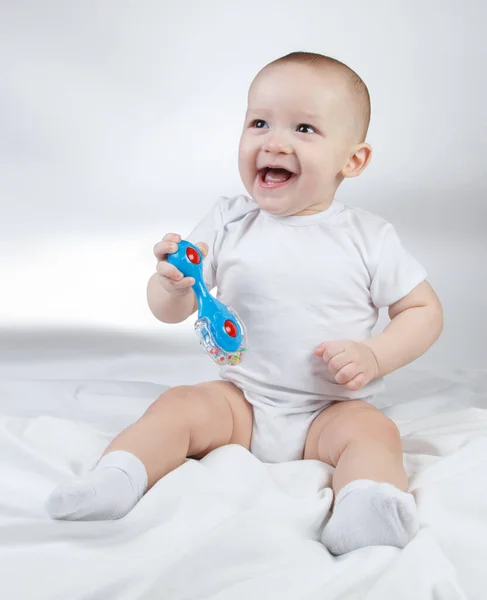 Image of a ten-month-old baby boy holding blue rattle — Stock Photo, Image