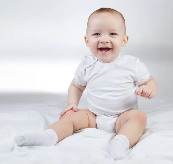 Foto de um bebê sorridente de dez meses em um fundo branco — Fotografia de Stock