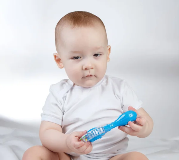 Photo of a ten-month-old baby boy with blue rattle — Stock Photo, Image