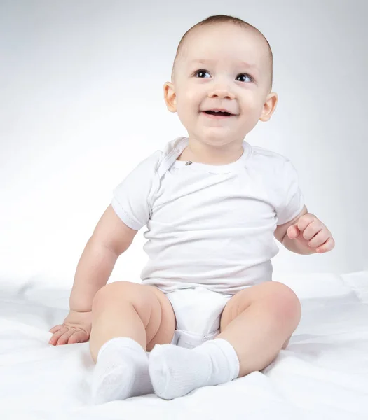 Foto de um bebê sorridente de dez meses olhando para a esquerda e para cima — Fotografia de Stock