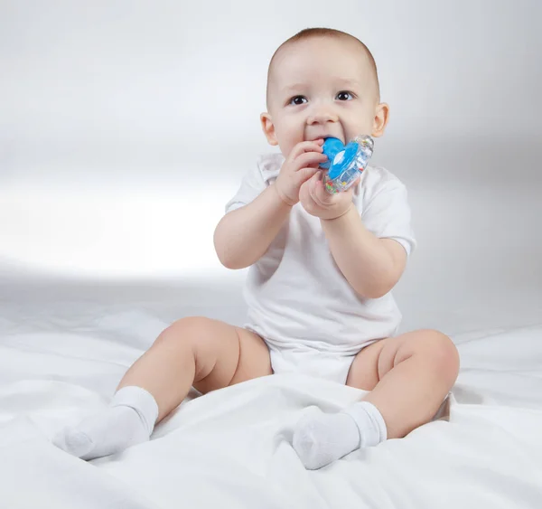 Photo of a ten-month-old baby with blue rattle — Stock Photo, Image