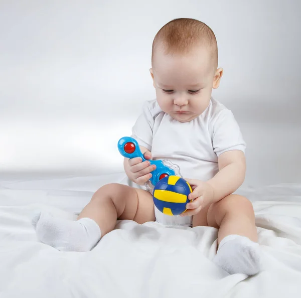 Image of a ten-month-old choosing baby between rattle and ball — Stock Photo, Image