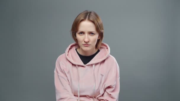 Schieten van jonge frons vrouw in roze sweatshirt — Stockvideo