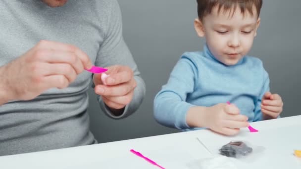 Footage of father and son sculpting toys from plasticine — Stock Video