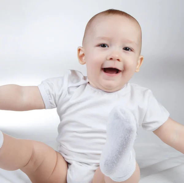 Bebê sorridente de dez meses em um fundo branco — Fotografia de Stock