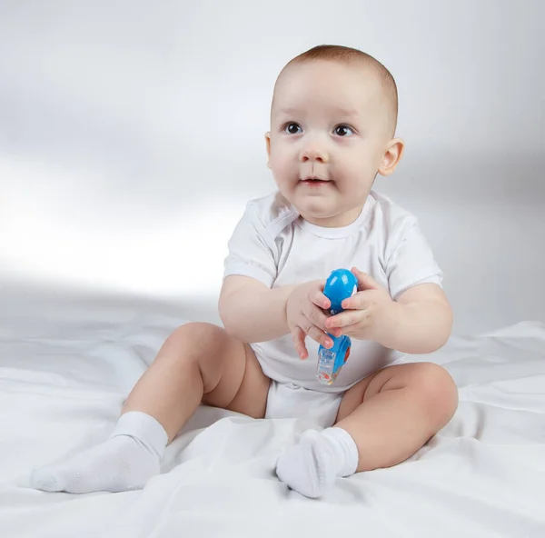 Image of a ten-month-old baby boy with blue rattle — Stock Photo, Image