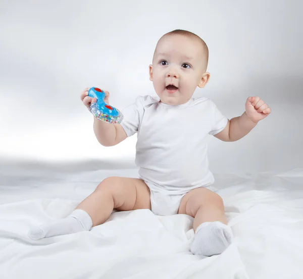 Photo of a ten-month-old baby boy holding blue rattle — Stock Photo, Image