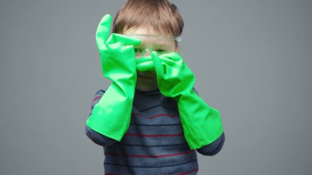 Little serious boy in protective gloves and glasses — Stock Video