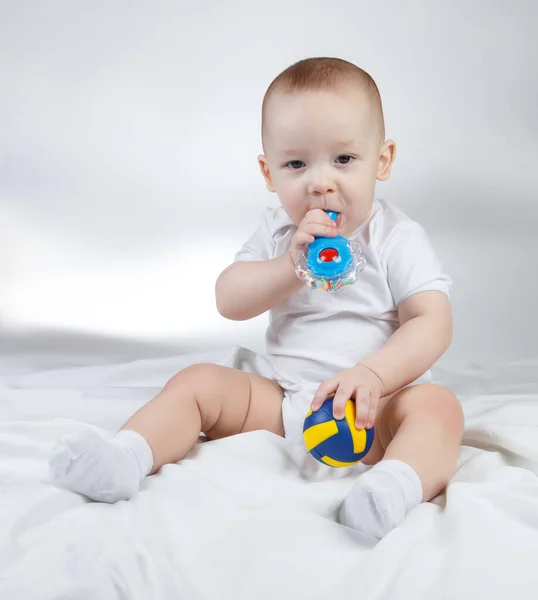 Foto di un bambino di dieci mesi con sonaglio e palla — Foto Stock