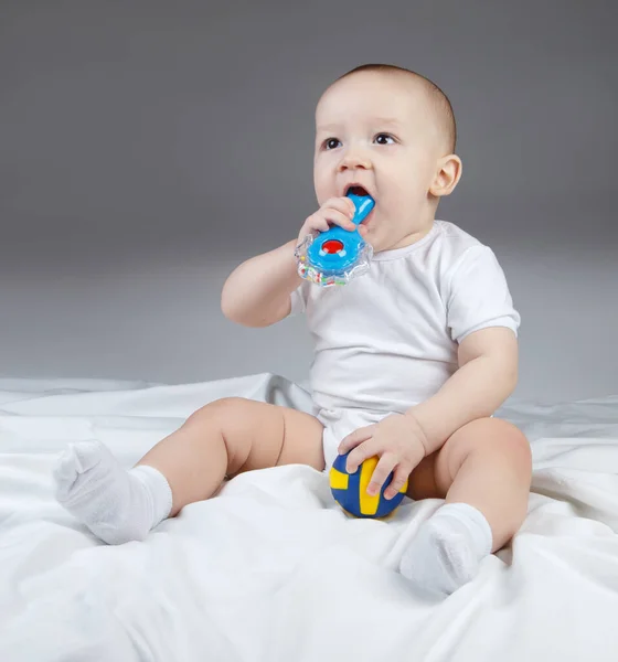 Image of a ten-month-old baby with rattle and ball — Stock Photo, Image