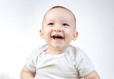 Beyaz arka planda on bir aylık bebeğe bakarken çekilmiş bir fotoğraf.