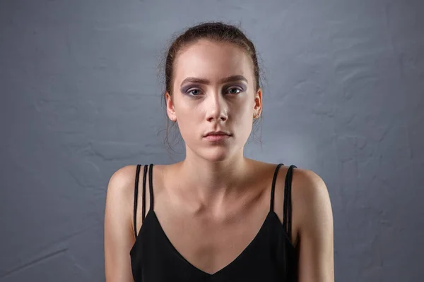 Image de jeune femme avec un maquillage inachevé sur fond gris — Photo