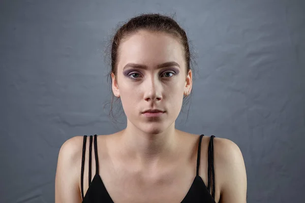Gri arkaplanda tamamlanmamış makyajlı bir kız resmi — Stok fotoğraf