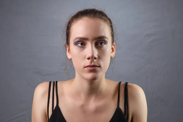 Foto de mujer joven con maquillaje inacabado mirando hacia arriba — Foto de Stock