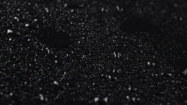 Siyah cam zemin üzerinde yağmur damlalarının çekilmesi