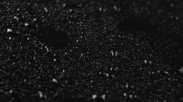 Зйомки дощових крапель на фоні чорного скла — стокове відео