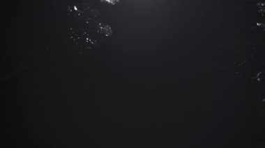 Siyah zemin üzerine ıslak damlaların püskürtüldüğü video