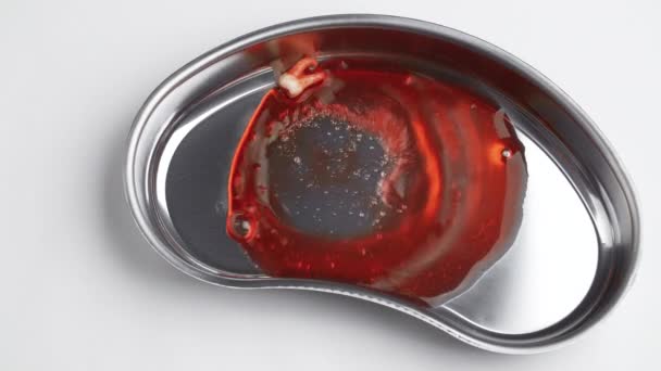 Filmación de una muela ensangrentada en una bandeja en forma de riñón — Vídeo de stock