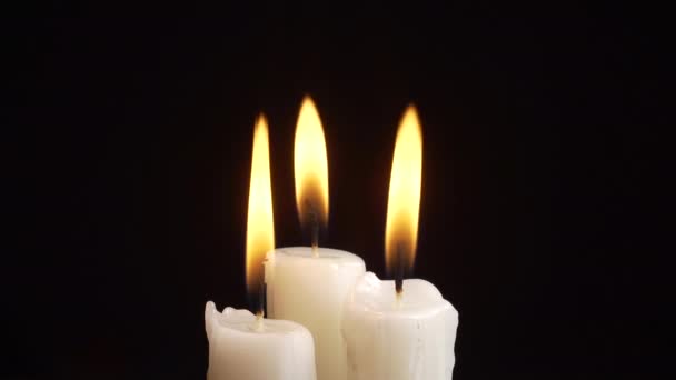 Видео зажигания трех свечей на черном фоне — стоковое видео