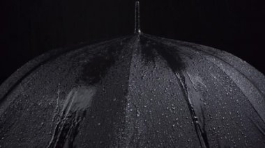 Siyah arka planda siyah şemsiye ve su damlalarının videosu