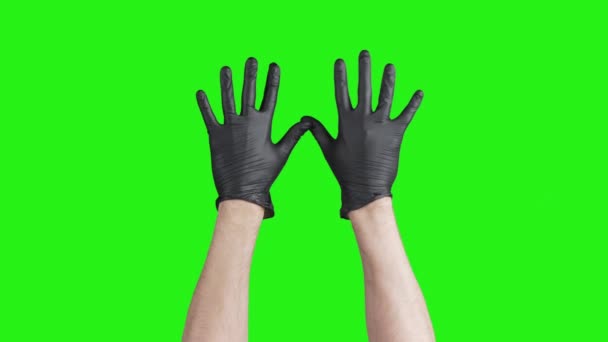 Erkek ellerinin yeşil arka planda siyah eldivenlerini çıkardığı video. — Stok video