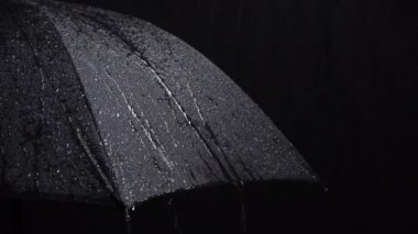 Siyah şemsiye ve siyah arkaplanda yağmur damlaları görüntüsü