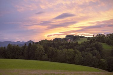 Jura Dağları üzerinde günbatımı manzaralı bir gökyüzü. Tepelerin üzerinde akşam renkli gökyüzü. İsviçre 'nin Naturpark Thal, İsviçre manzarası.