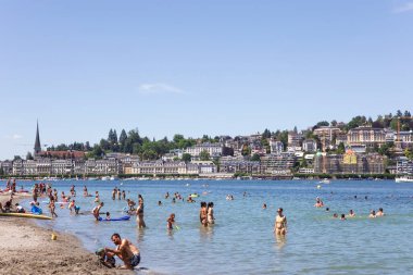 Lucerne, Canton Lucerne / İsviçre - 07 / 09 / 2020: Lucerne Gölü belediye plajı. Gölde yıkanan ve kıyıda dinlenen insanlar. Şehrin mimarisine bak, yaz günü. İsviçre